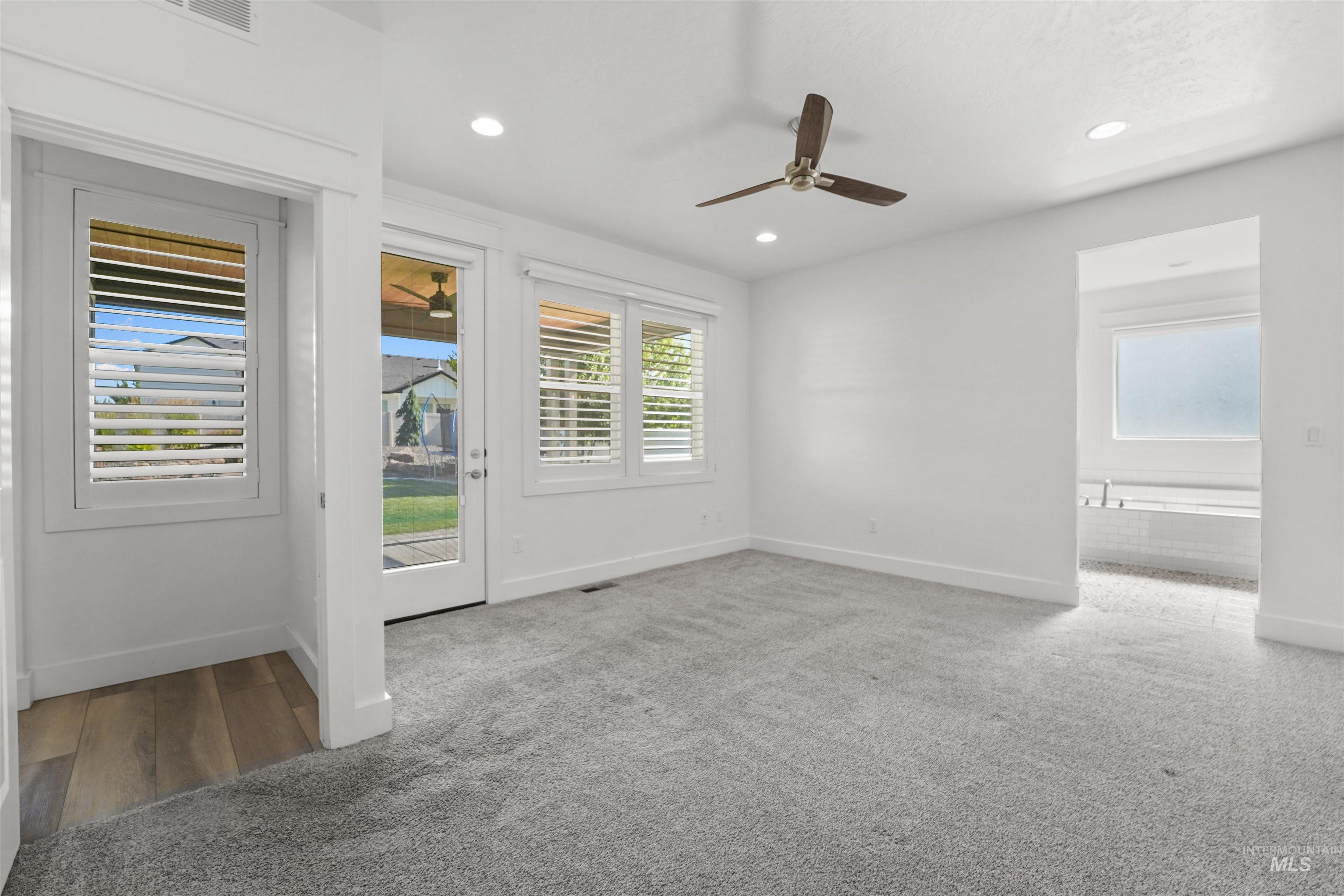 Carpeted spare room featuring a ceiling fan and recessed lighting