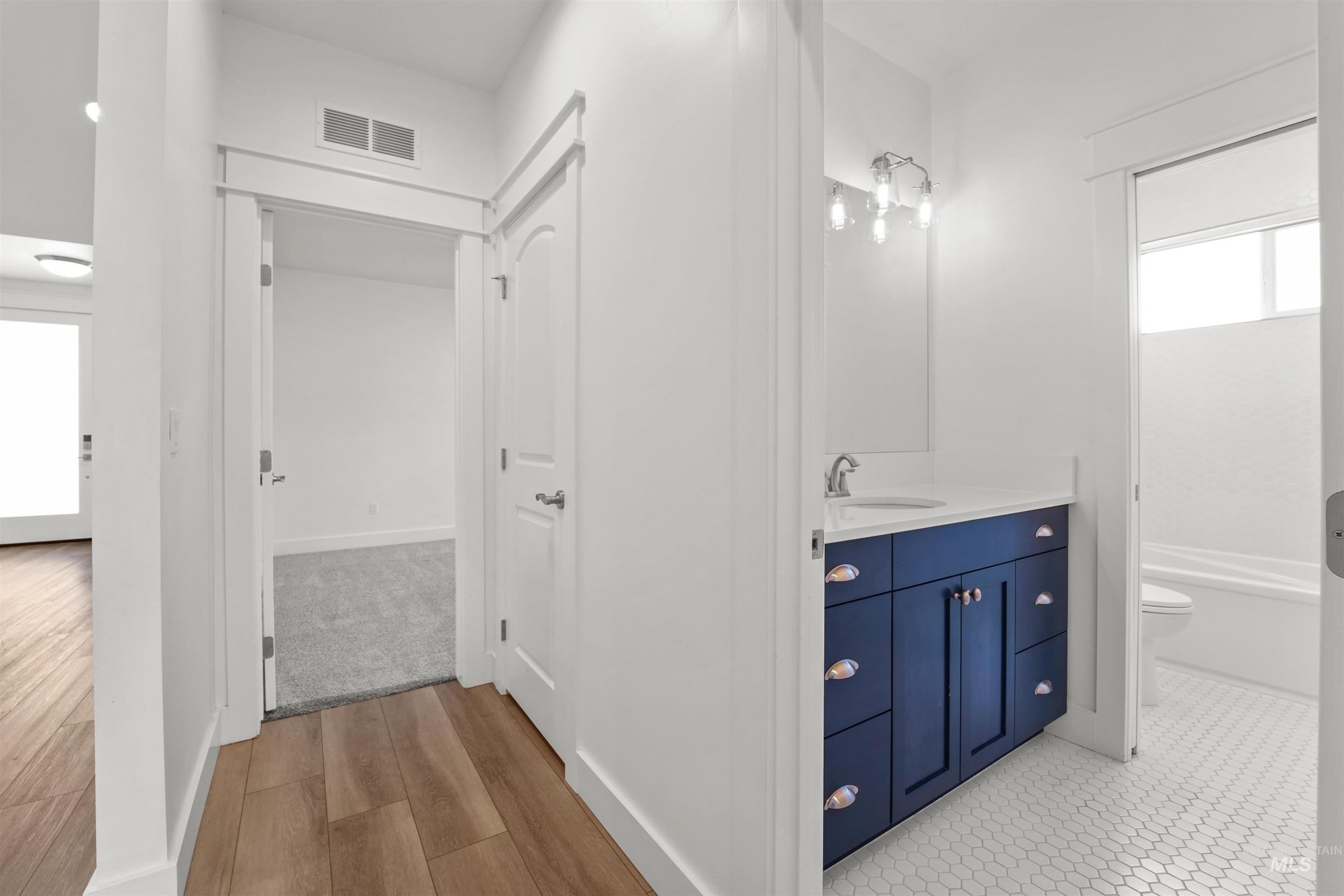 Bathroom with vanity, wood finished floors, and a bathtub