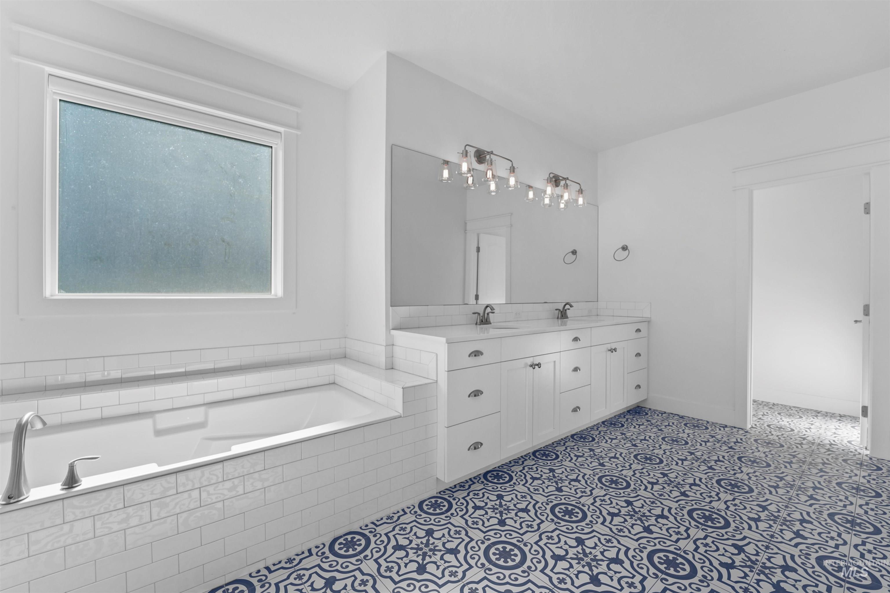 Bathroom featuring double vanity and a garden tub
