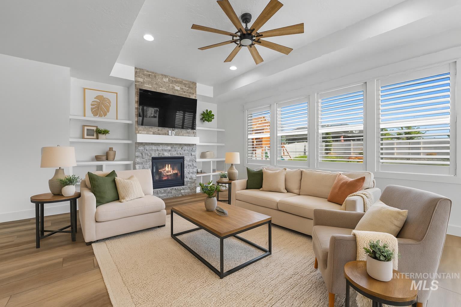 Living area featuring ceiling fan, light wood-type flooring, recessed lighting, a fireplace, and built in features