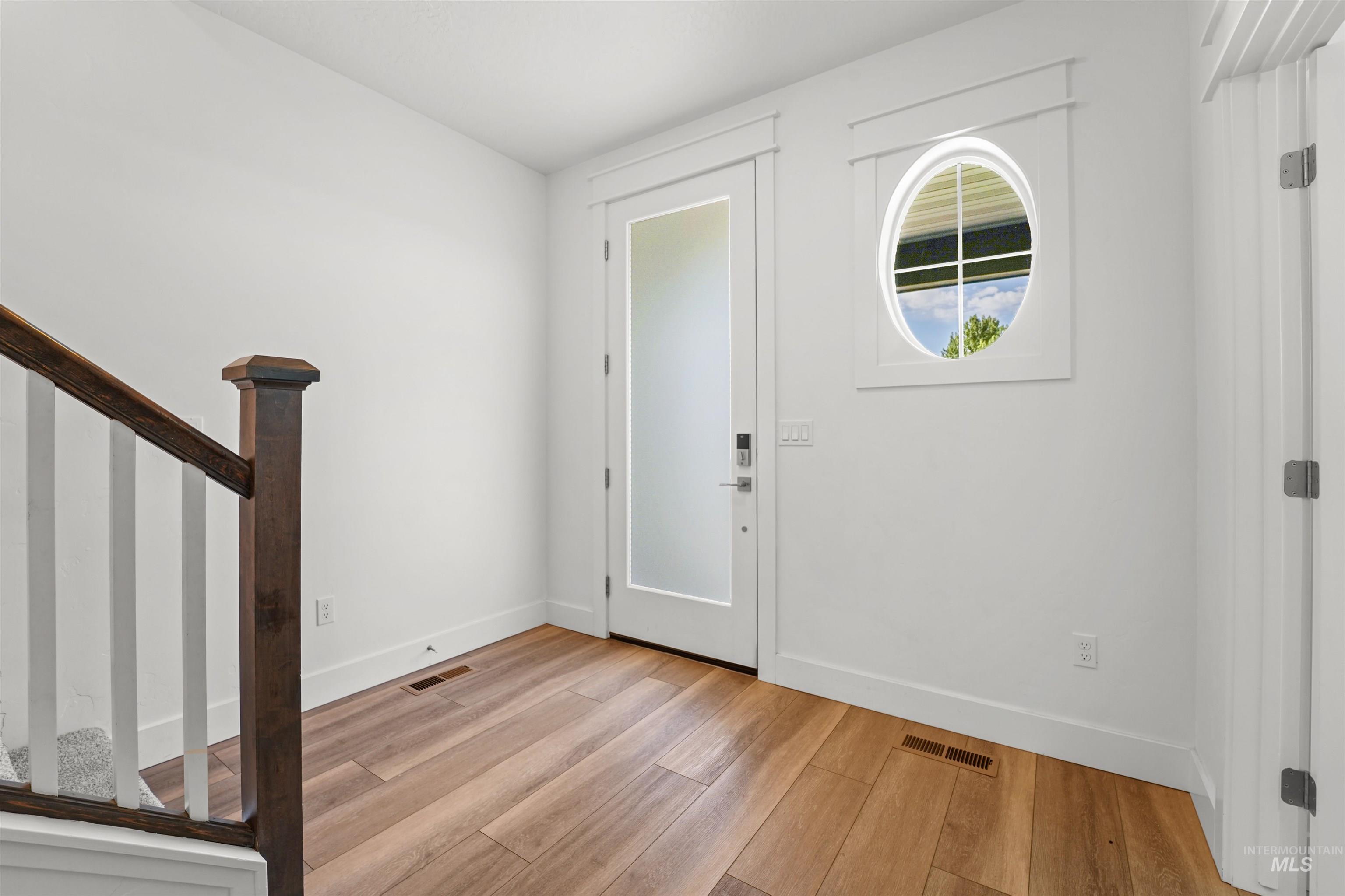 Foyer with light wood finished floors and stairway