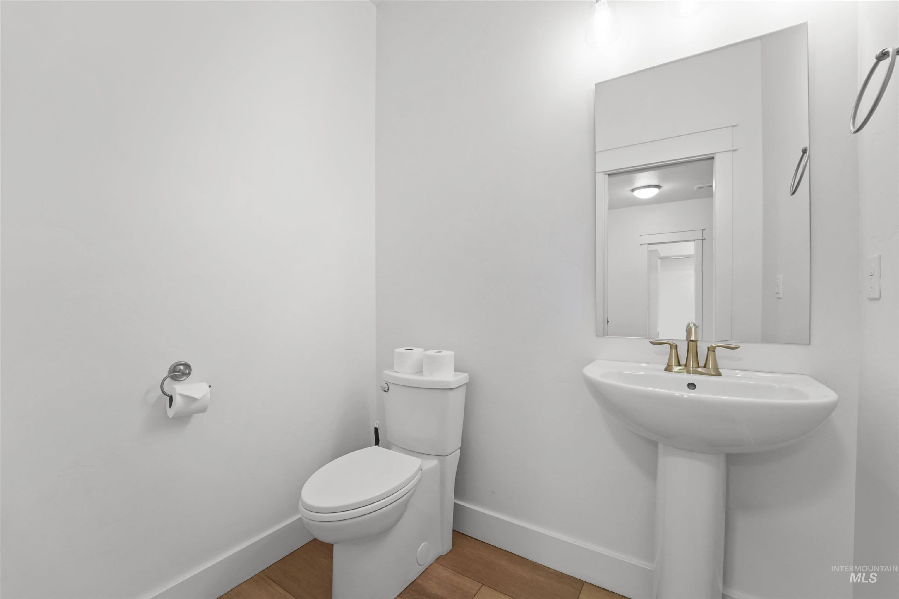 Bathroom with toilet and wood finished floors