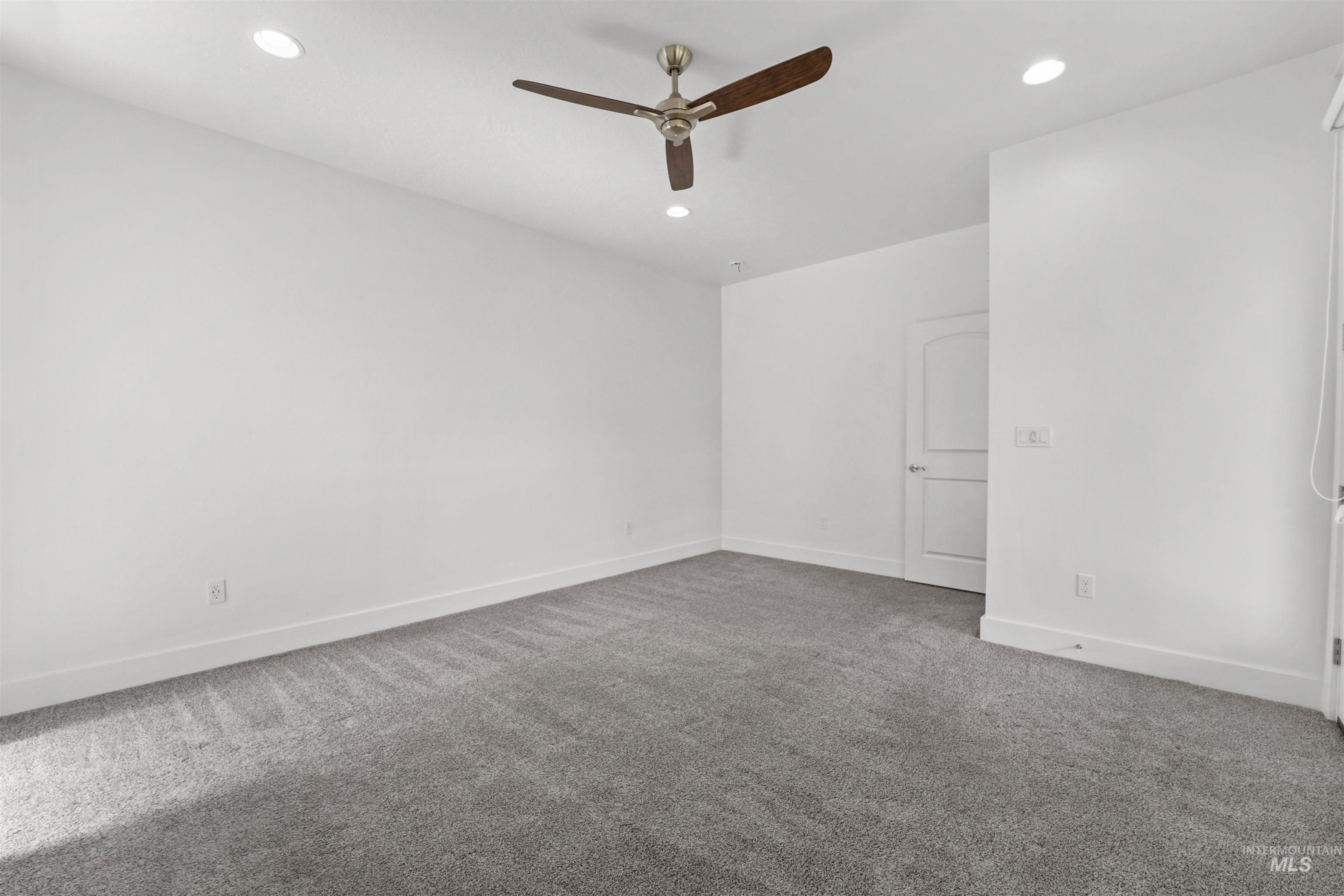 Empty room featuring a ceiling fan, carpet floors, and recessed lighting