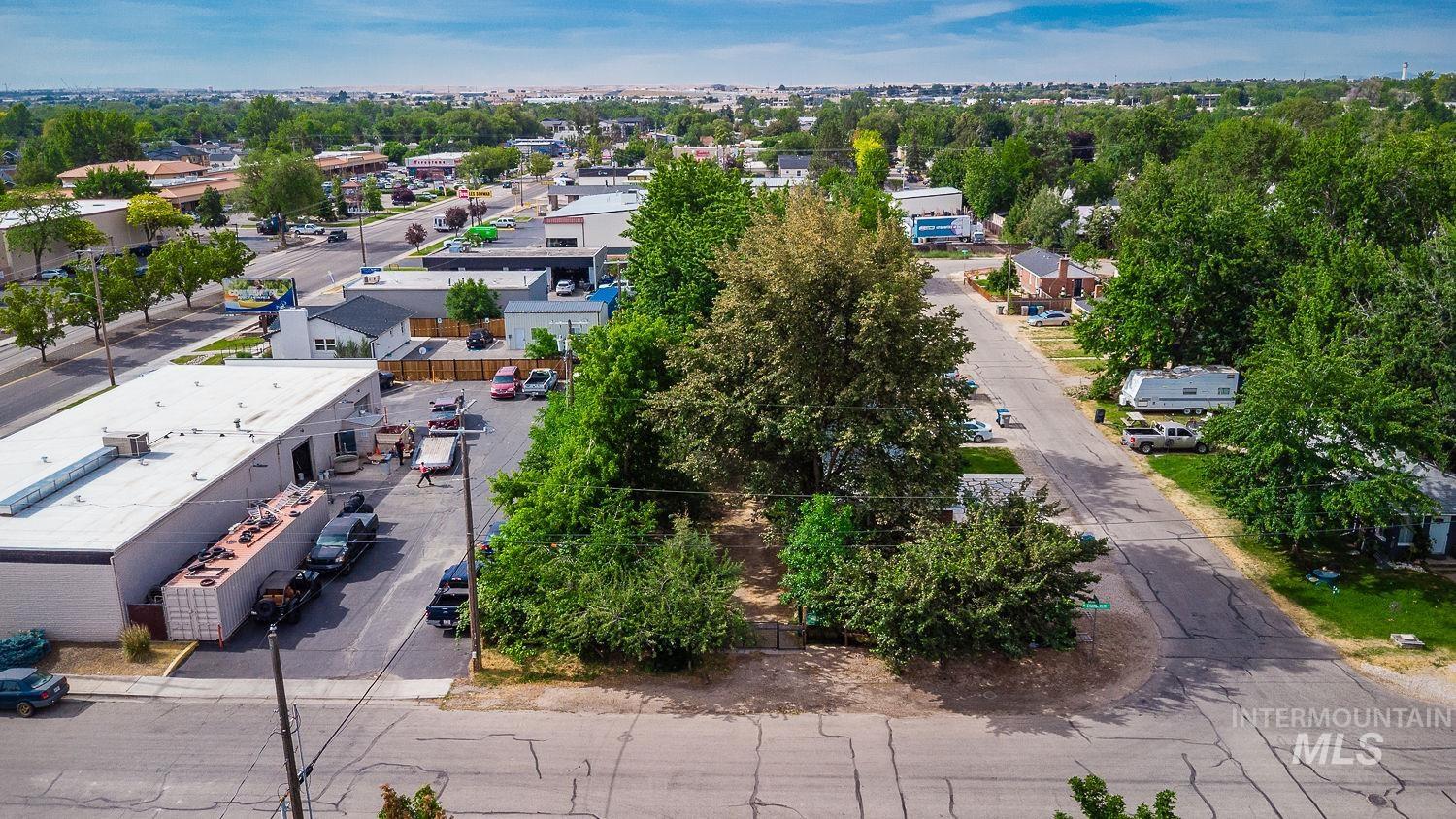 Aerial perspective showcasing a parcel with established trees and surrounding neighborhood