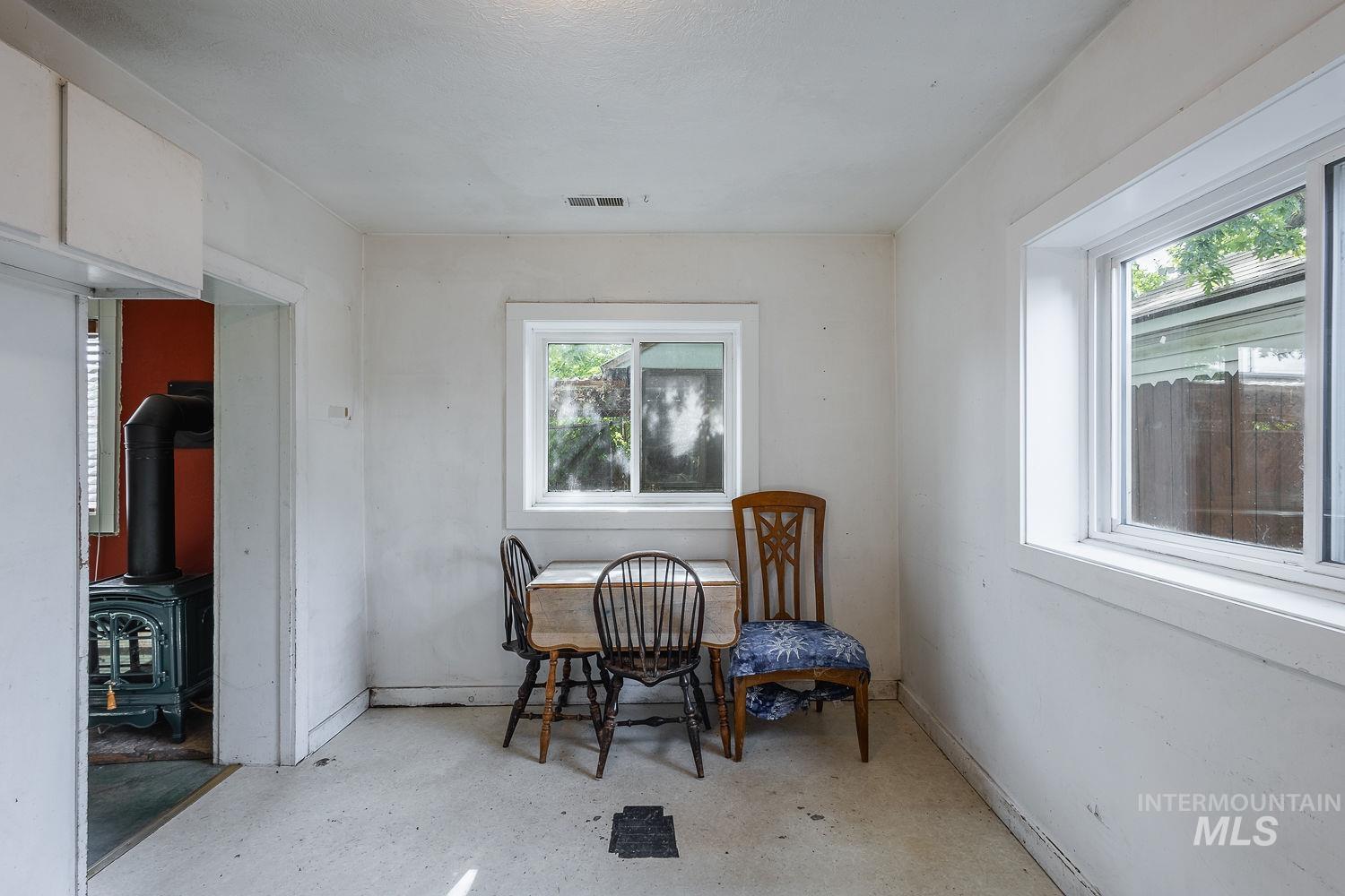 Open room featuring two white-framed windows, painted white walls, and a light-colored floor
