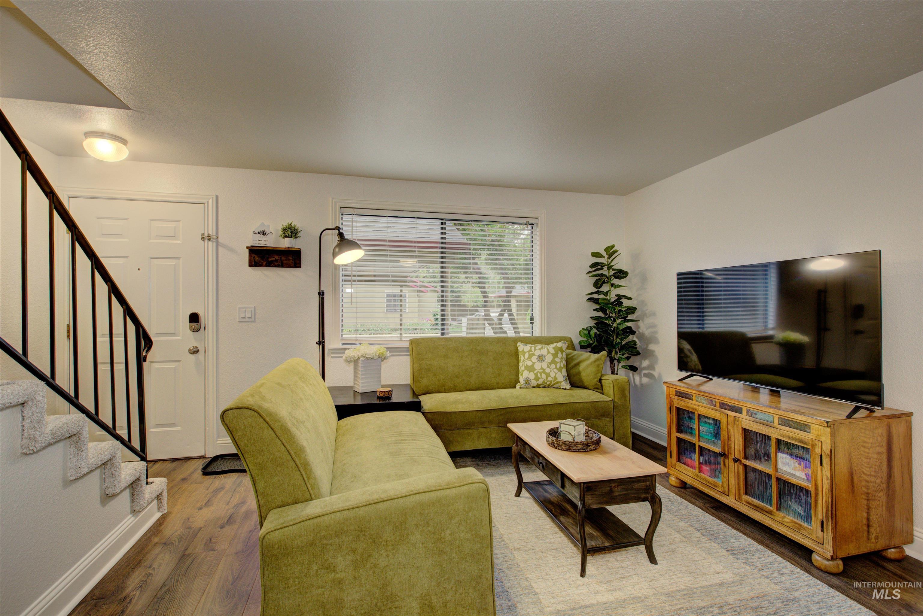 Living room with wood finished floors and stairway