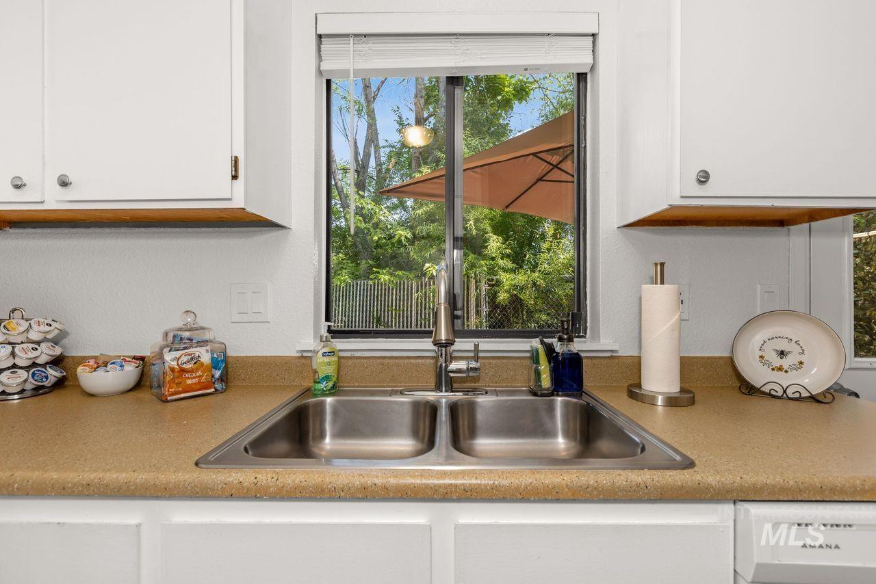 Kitchen with white cabinetry, light countertops, and dishwasher