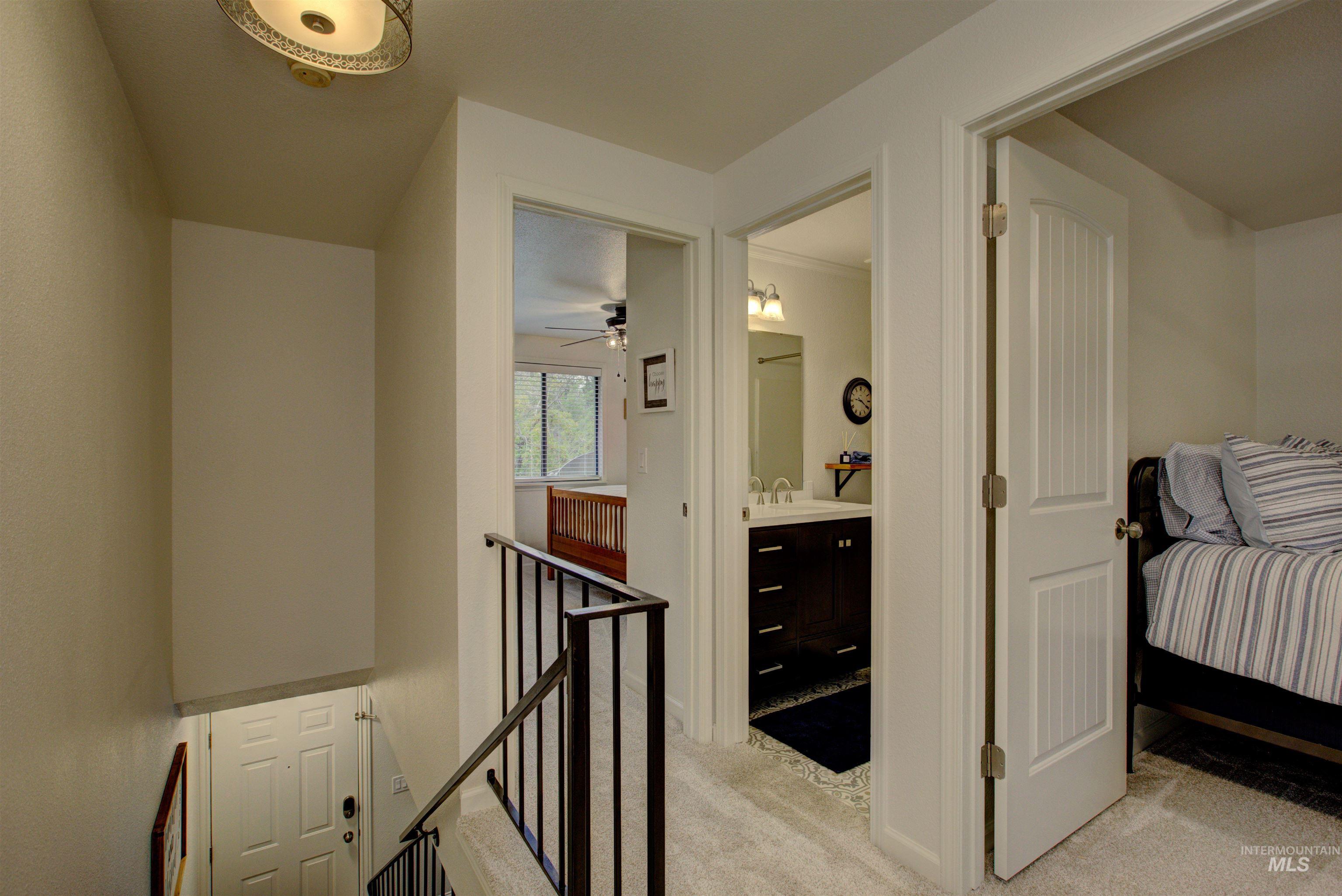 Corridor with an upstairs landing and light carpet
