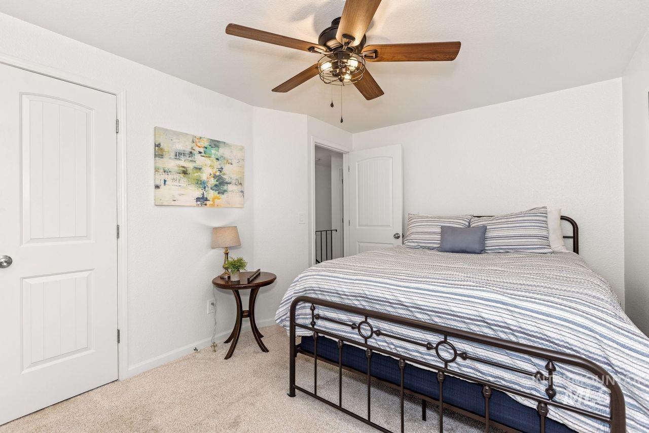 Bedroom with light carpet and a ceiling fan