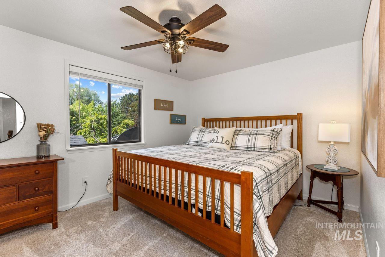 Carpeted bedroom featuring baseboards and ceiling fan