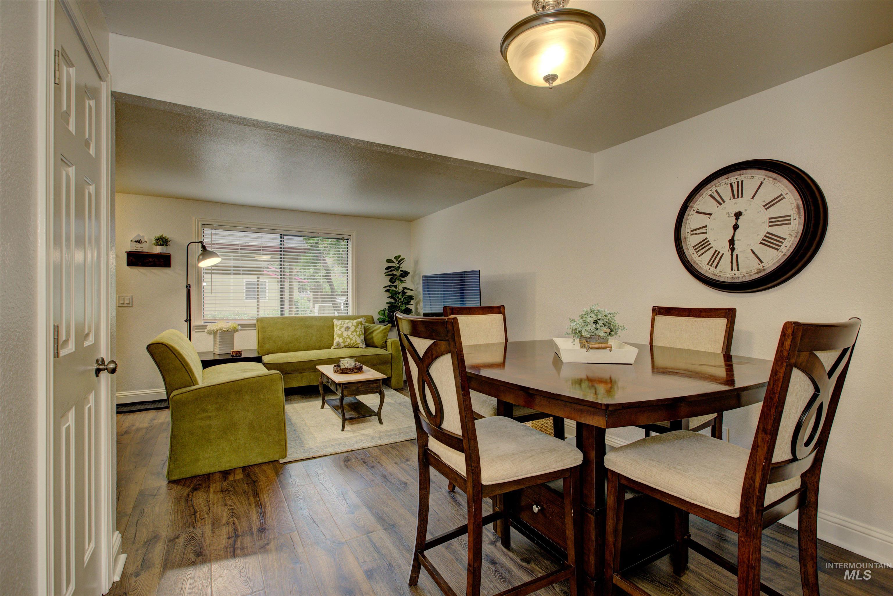 Dining area featuring dark wood-style floors and baseboards