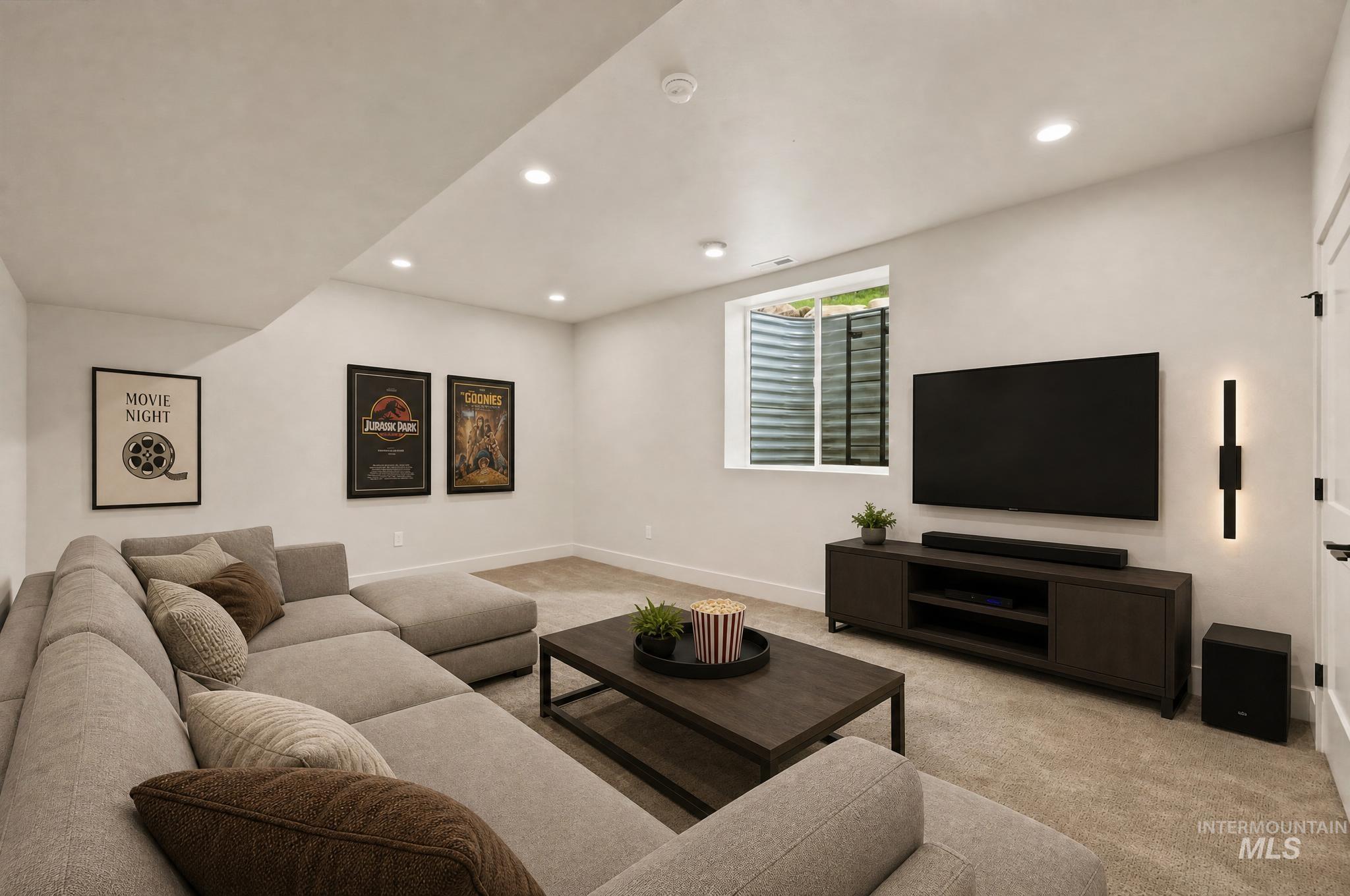 Finished basement space featuring recessed lighting, a window with a window well, a built-in media console, and light-colored carpeting - Bonus Room Main Floor