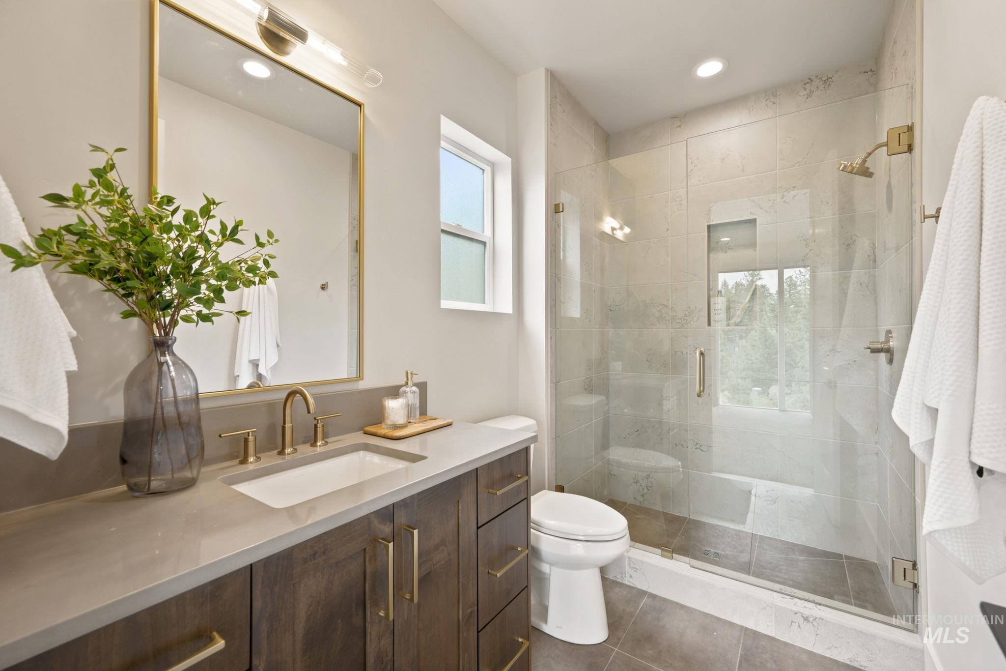 Modern bathroom featuring a wood-finish vanity with a light-toned countertop and an undermount sink