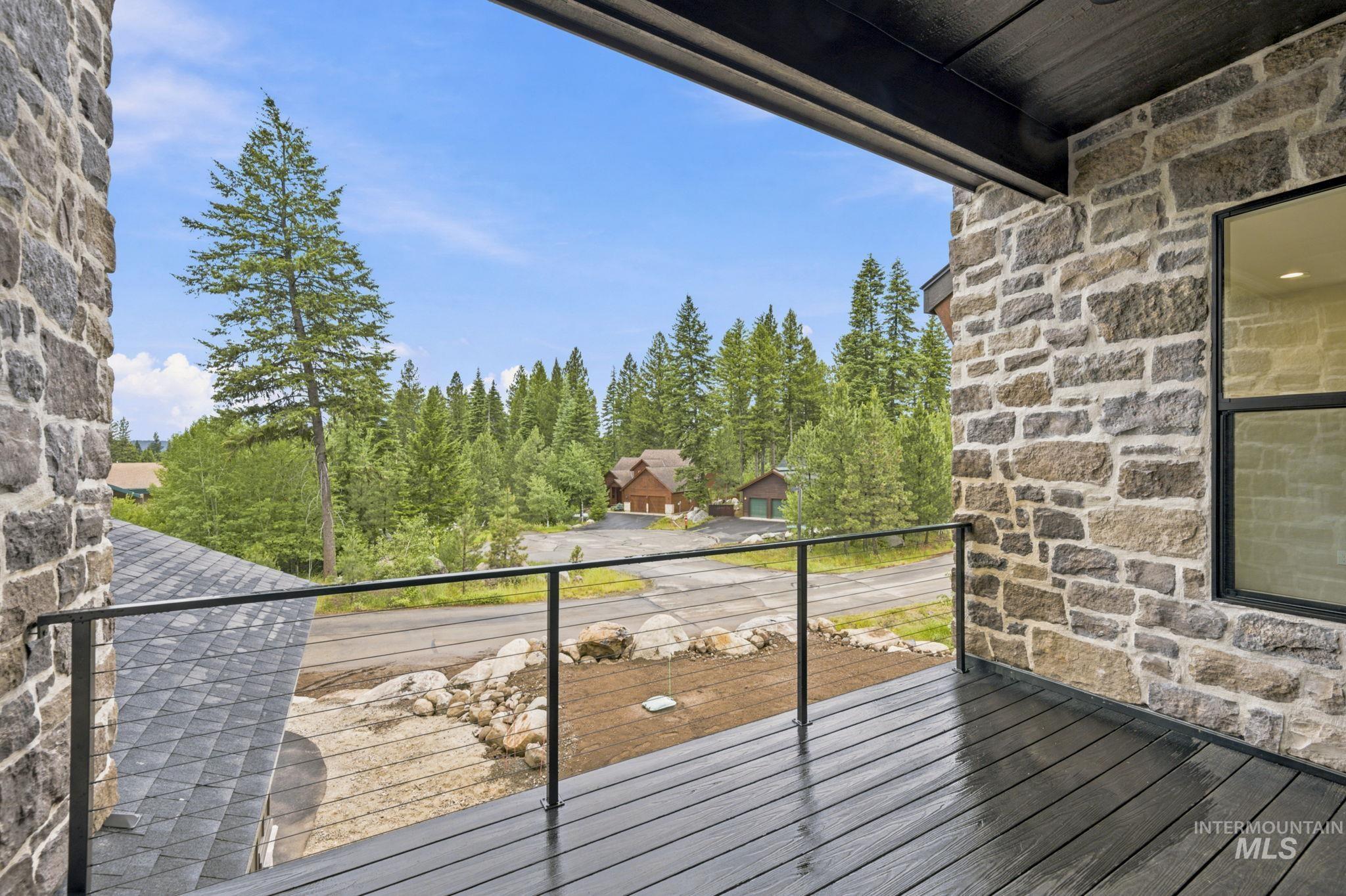 Exterior balcony featuring dark wood-finish decking and black cable railing - Second Floor
