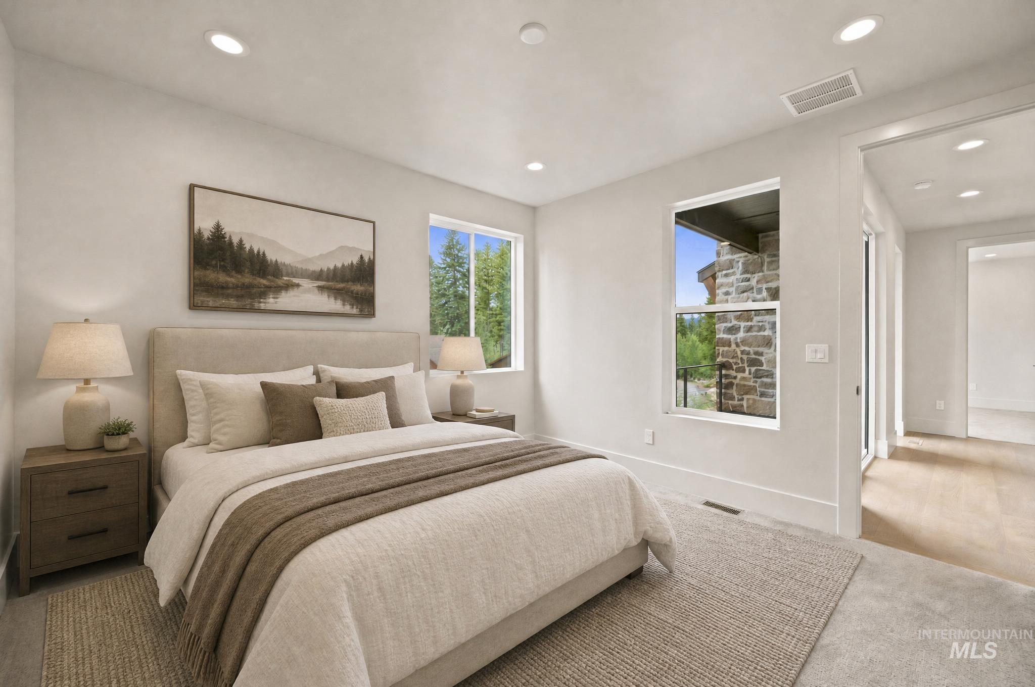 Carpeted room featuring recessed lighting, a window with stone exterior elements, and a doorway leading to a wood-finish flooring hallway - Ensuite Second Floor