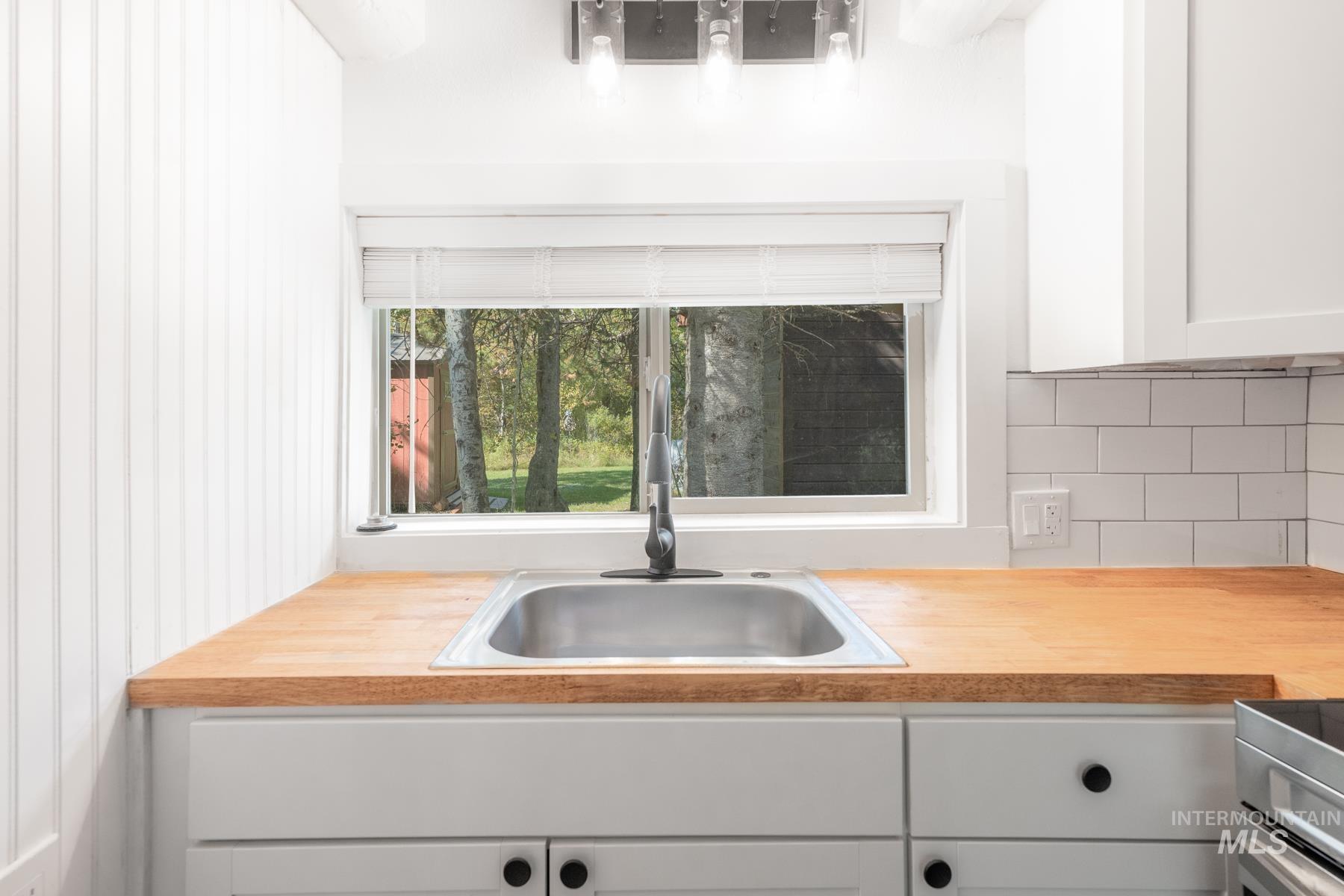 Kitchen featuring white cabinetry and a sink