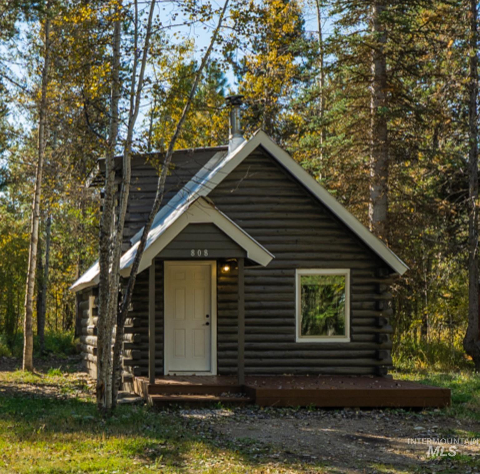 Cabin with log siding and a forest view
