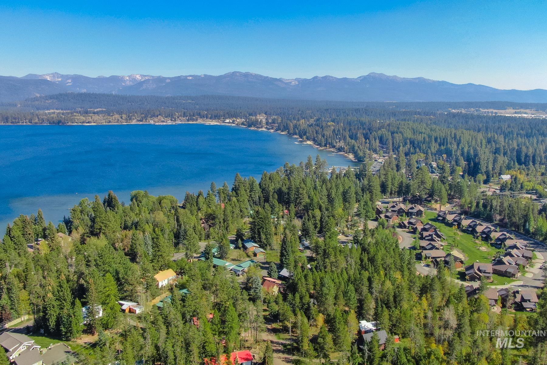Aerial view of property's location featuring a water and mountain view and a forest