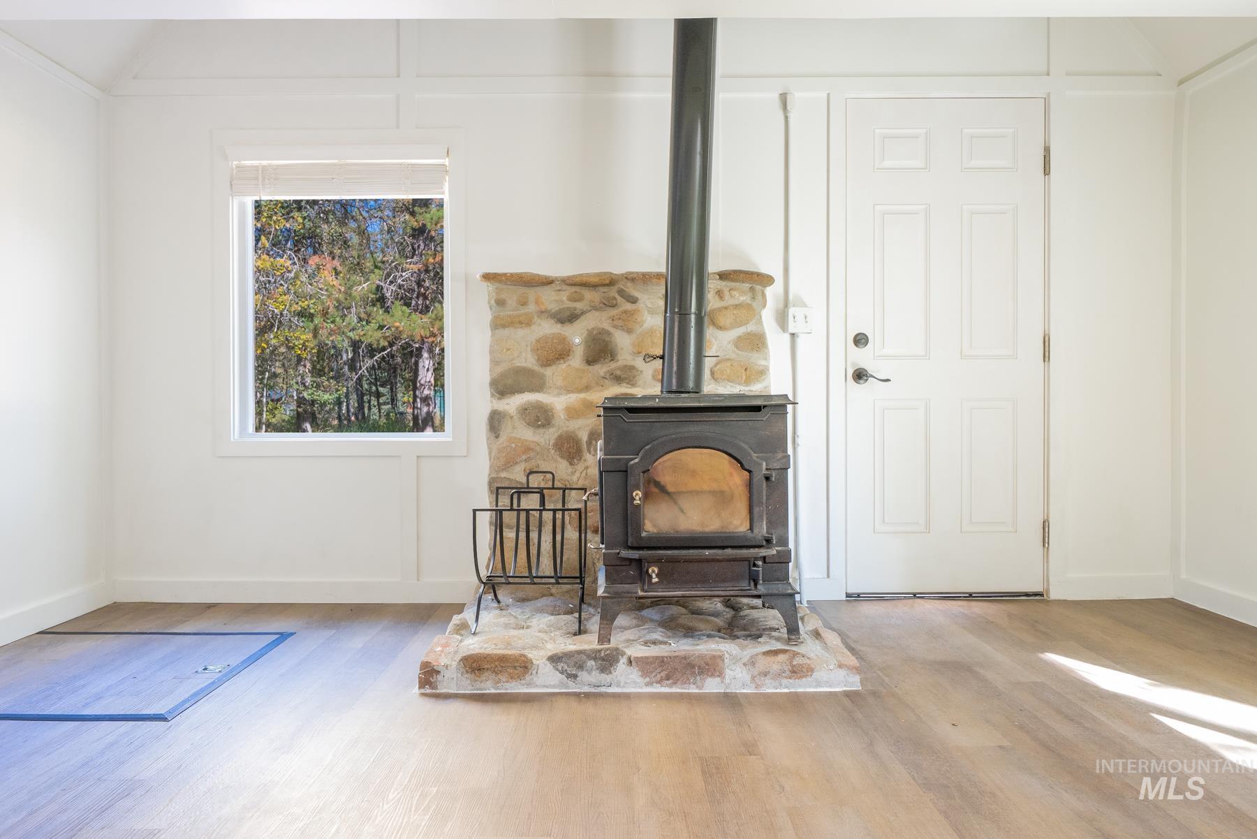 Living room with a wood stove and wood finished floors