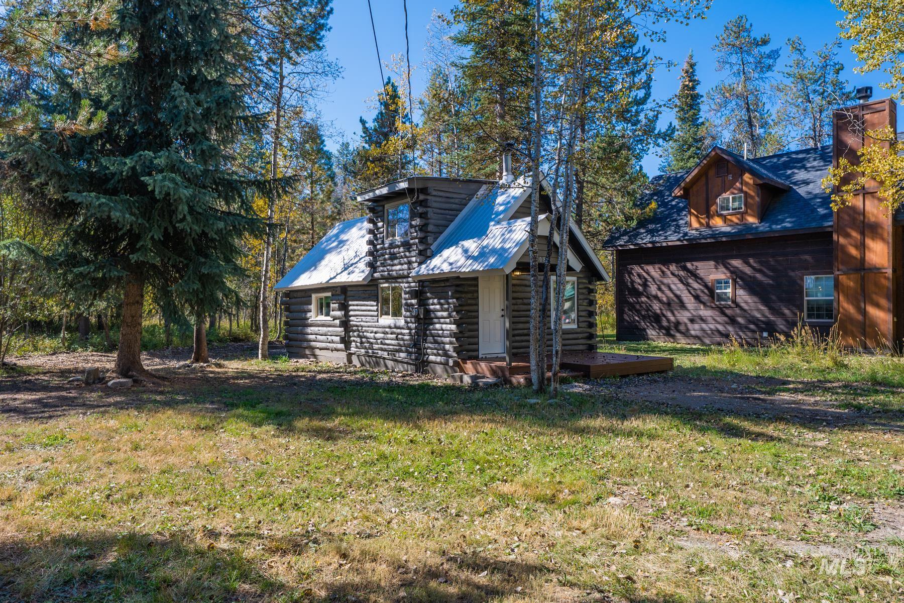Rear view of house featuring log siding, a yard, and a chimney