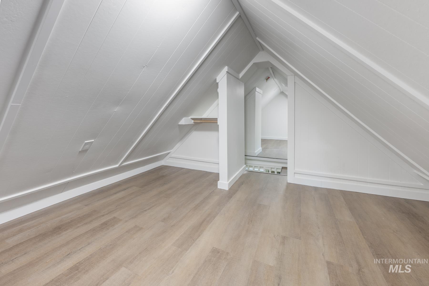 Bonus room featuring light wood-style flooring and vaulted ceiling