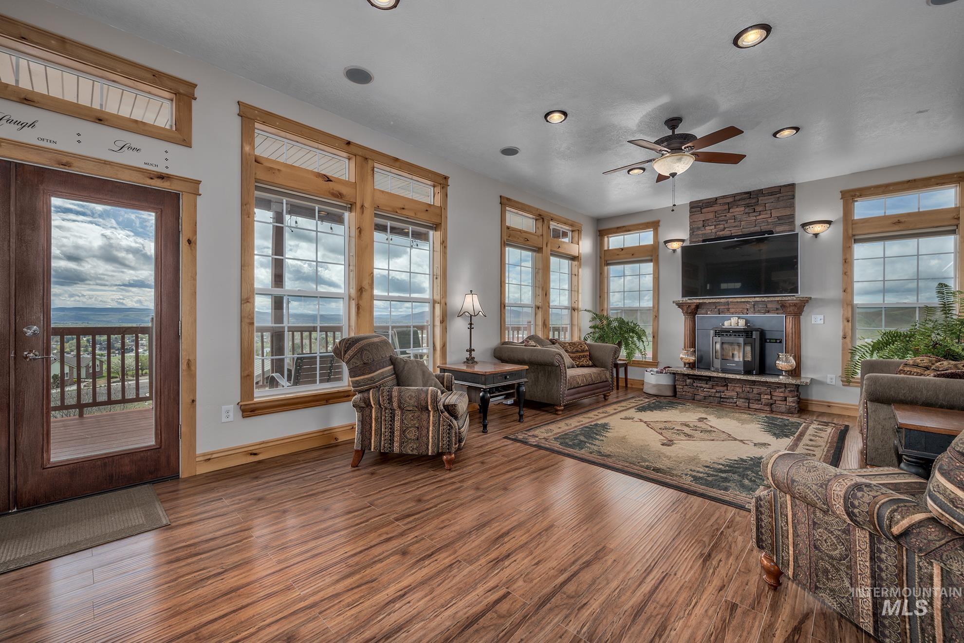 Living area featuring wood finished floors, ceiling fan, recessed lighting, and a fireplace