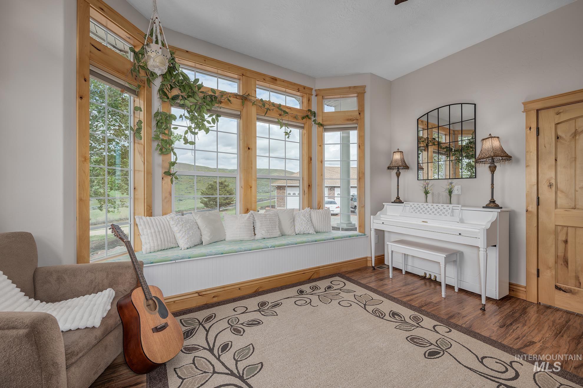 Music room or guest room with wood finished floors and plenty of natural light