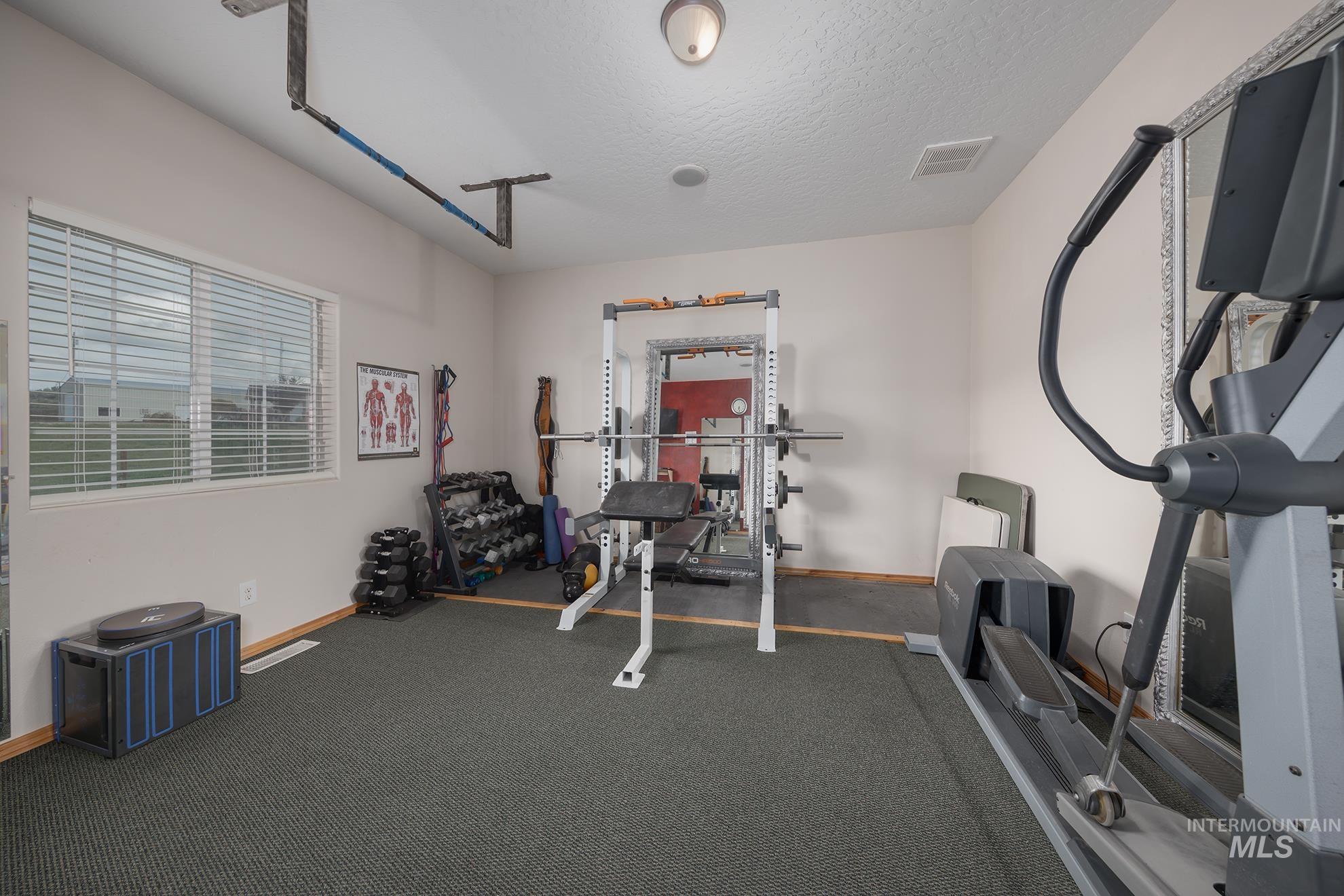 Workout area featuring baseboards and a textured ceiling
