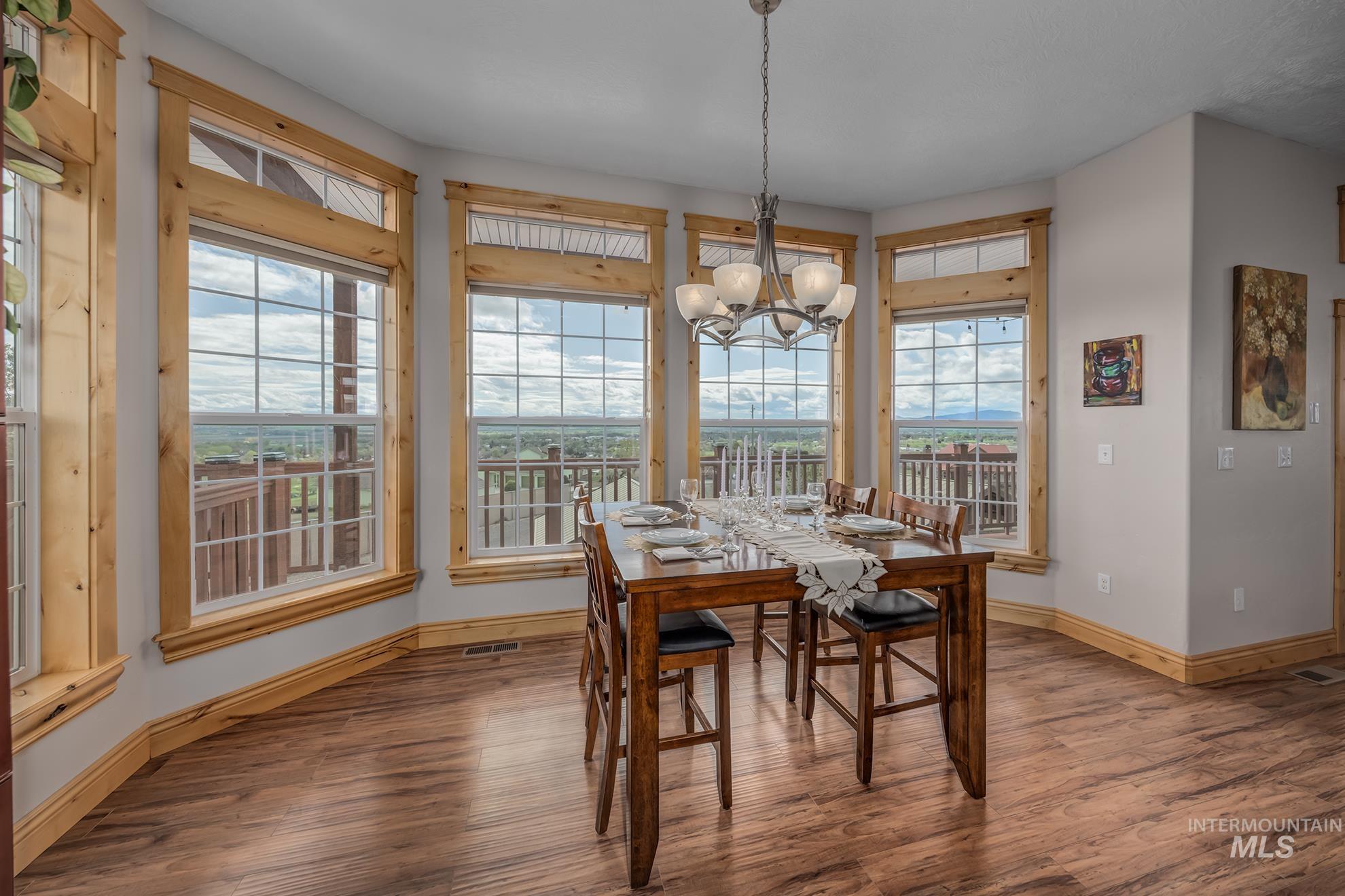 Dining area with wood finished floors and hanging lights