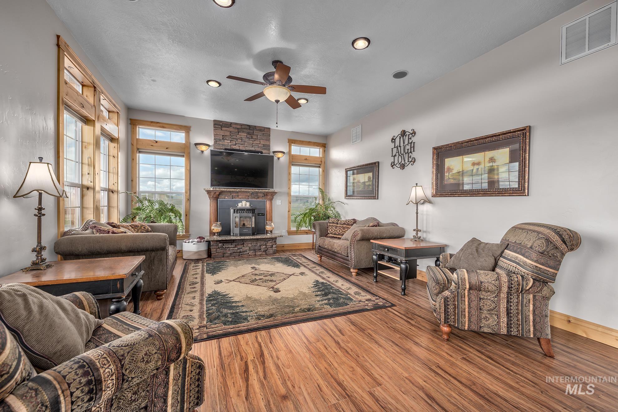 Living room with ceiling fan, wood finished floors, and recessed lighting
