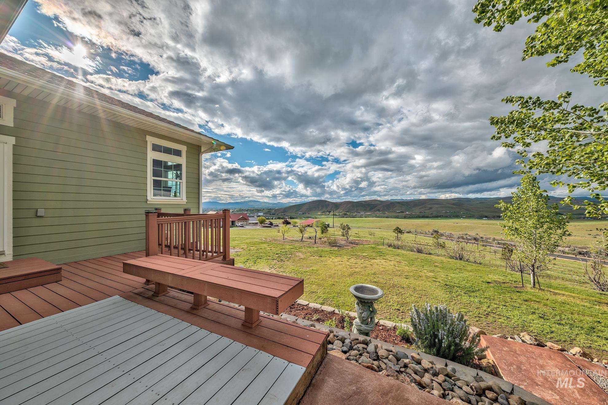 Deck with a yard, a mountain view, and a view of countryside