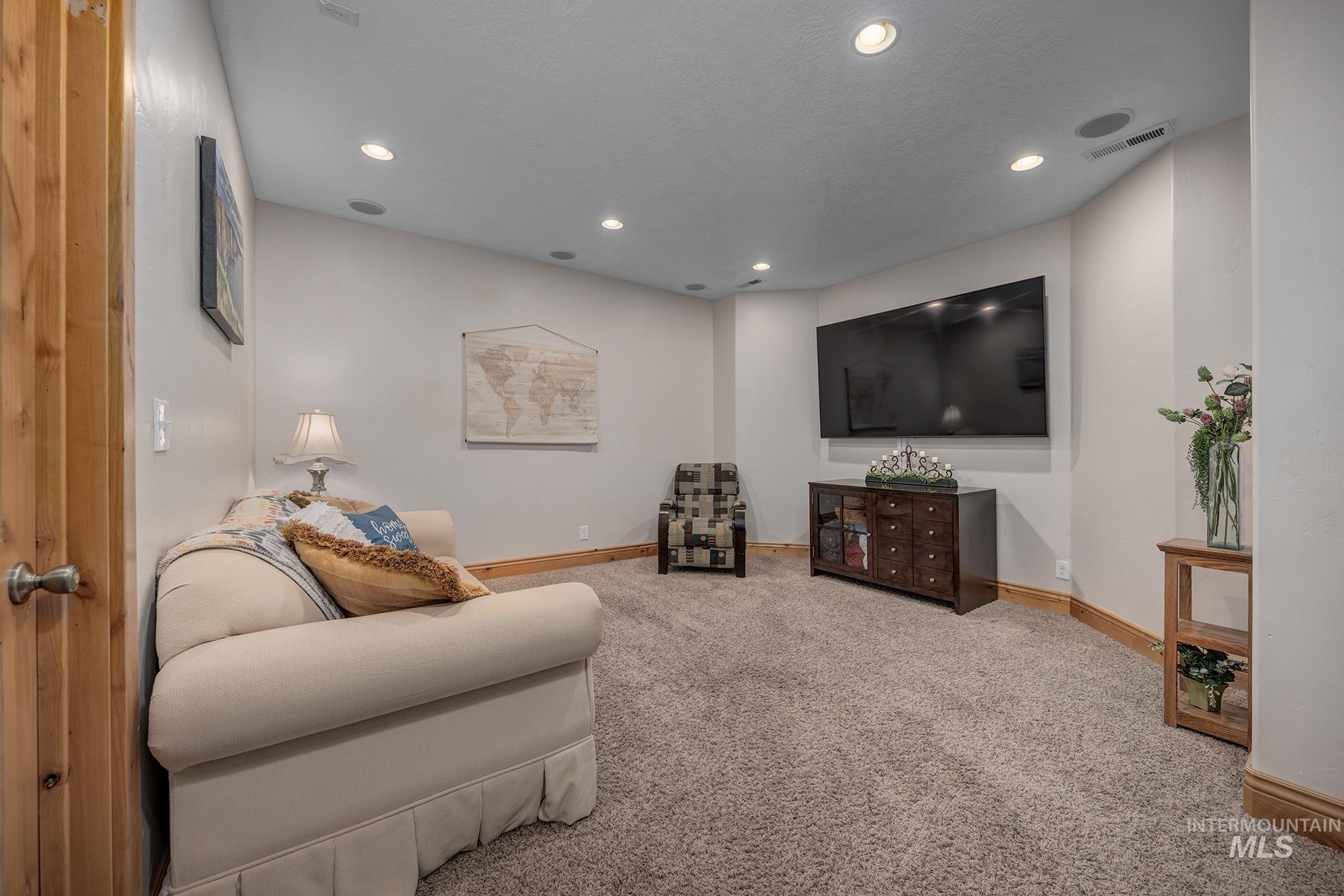 Family room with light colored carpet and recessed lighting