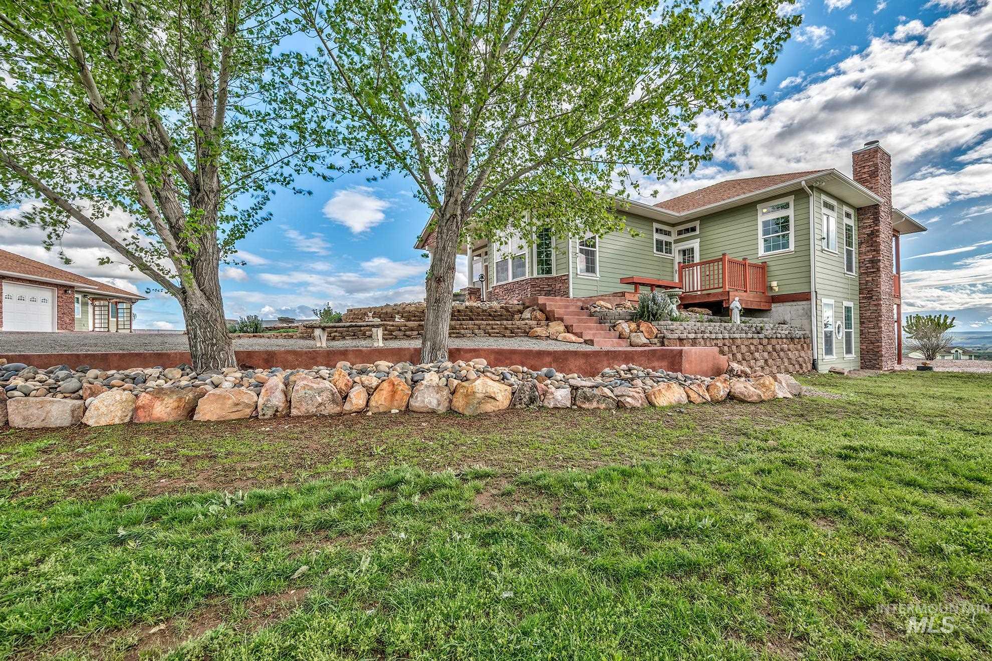 Side of property with a chimney and a lawn