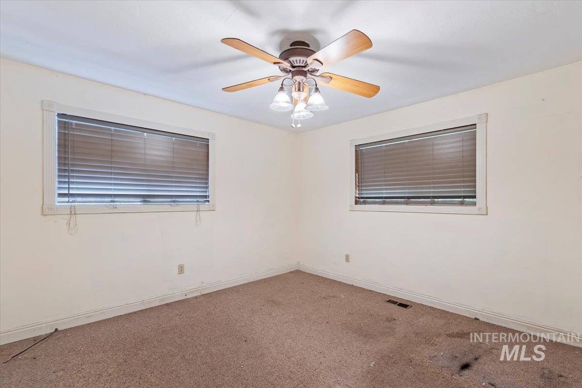 Unfurnished room with carpet and a ceiling fan