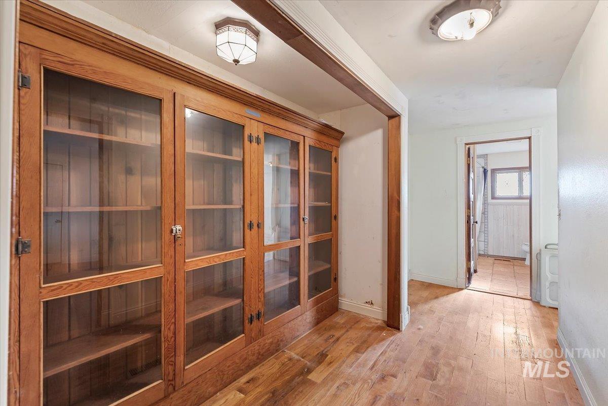 Hallway featuring light wood-type flooring and baseboards
