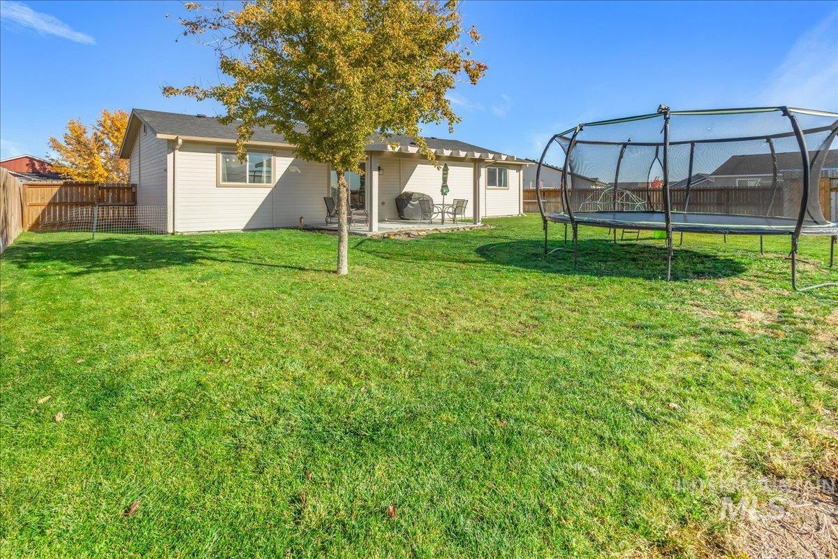 Fenced backyard featuring a patio and a trampoline