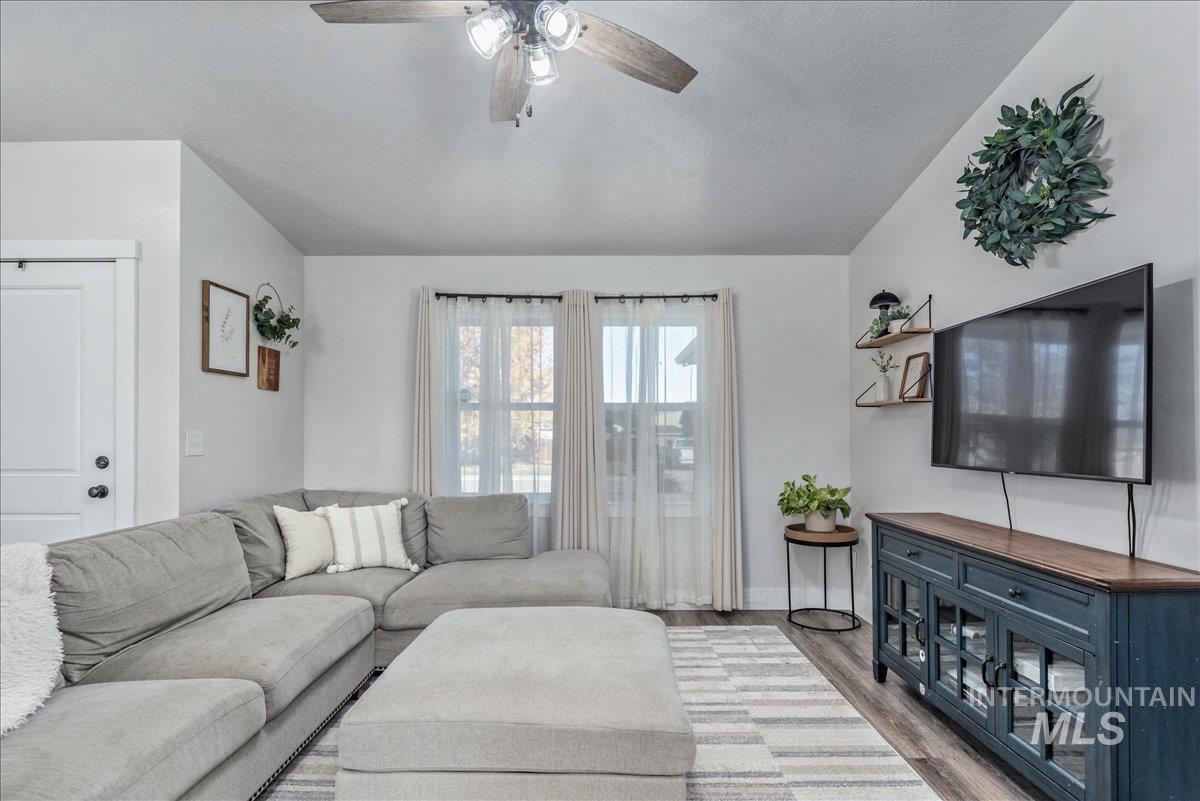 Living area with wood finished floors, ceiling fan, and a textured ceiling