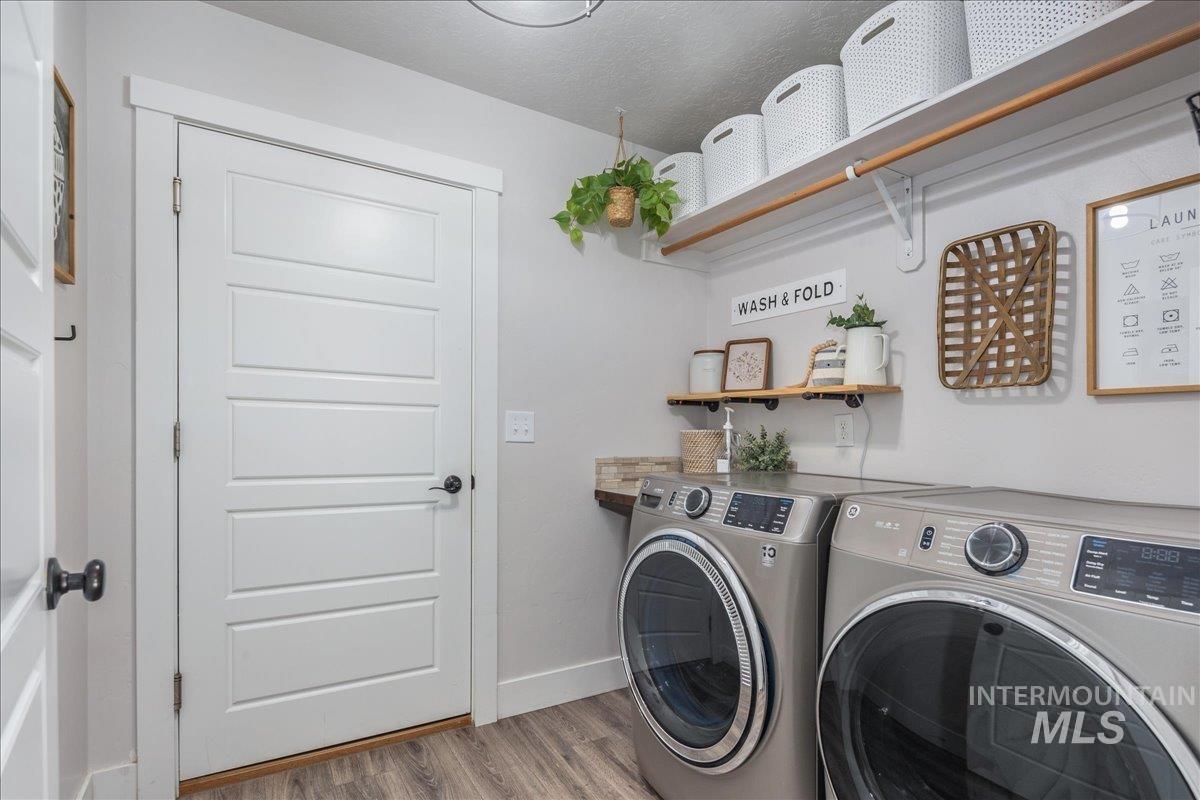 Laundry area featuring light wood finished floors and washing machine and dryer