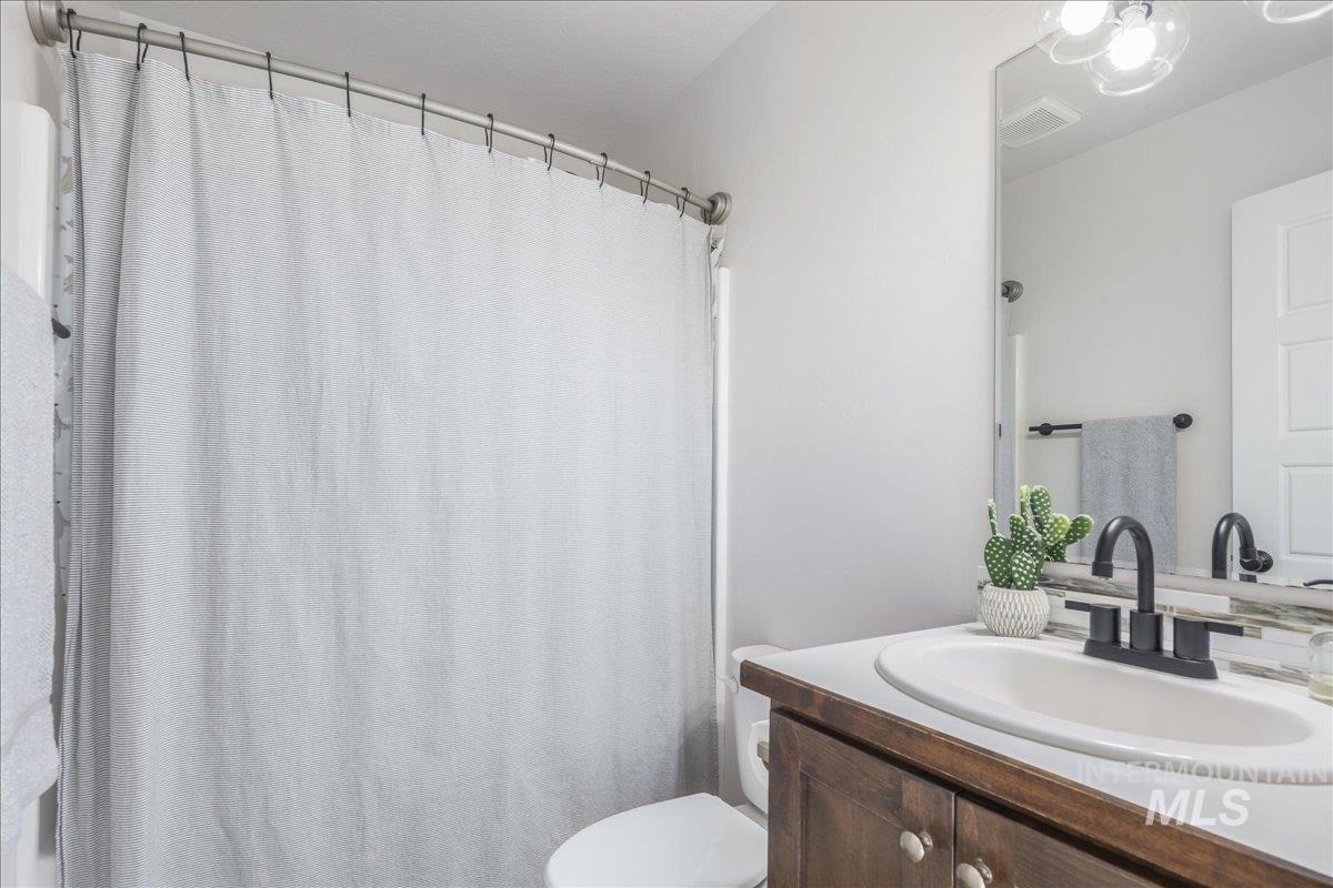Bathroom with curtained shower and vanity