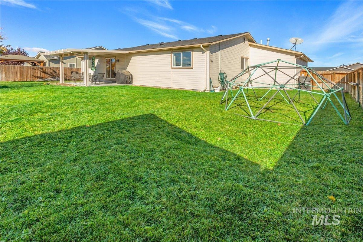 Rear view of house featuring a fenced backyard and a patio area