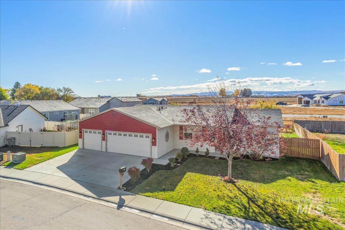 View of front of property with driveway, a garage, and a residential view