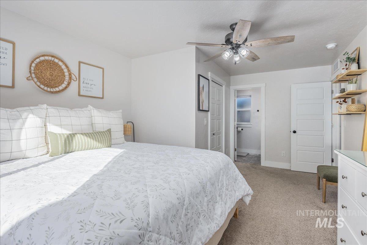 Bedroom featuring light carpet and a ceiling fan