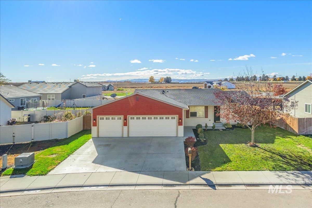 View of front of property featuring an attached garage, driveway, and a residential view