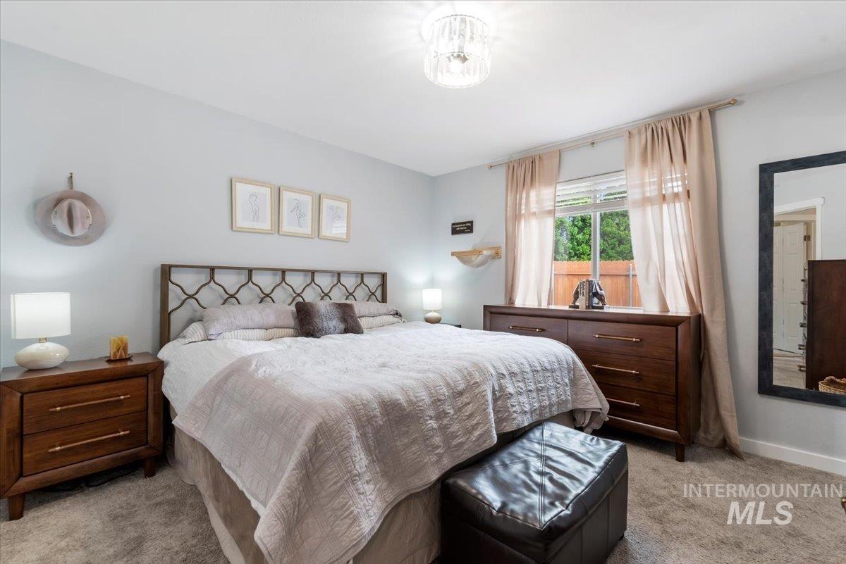 Carpeted bedroom featuring light-colored walls and a window with blinds