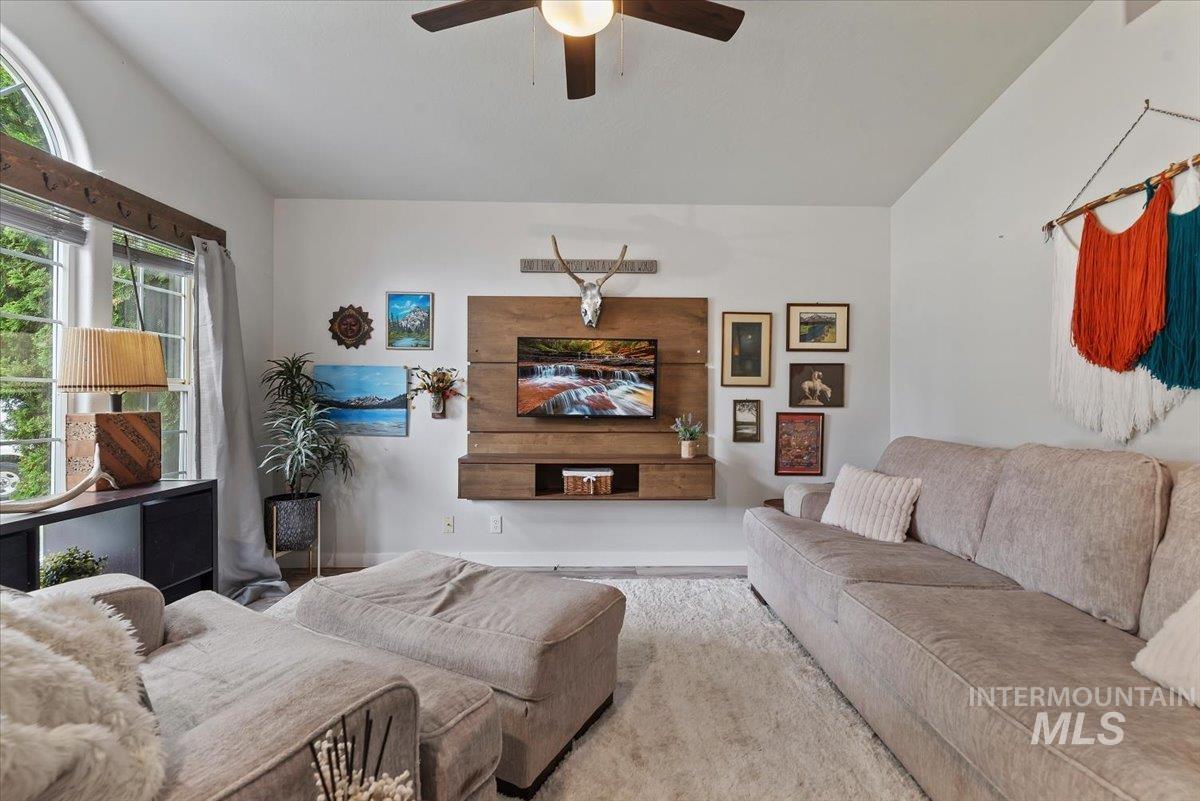 Vaulted ceiling living area featuring a prominent entertainment wall with integrated wood-finish shelving