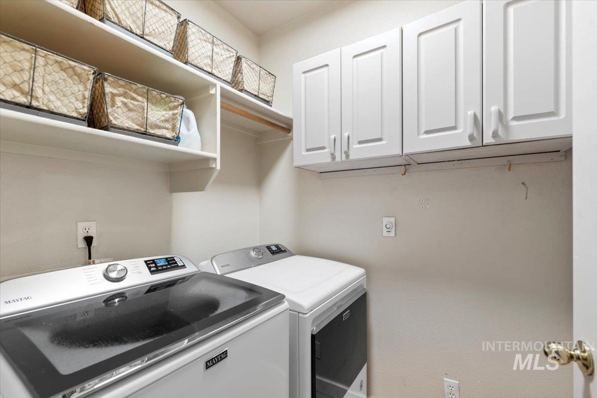 Laundry area featuring white cabinetry, open shelving, and a built-in hanging rod