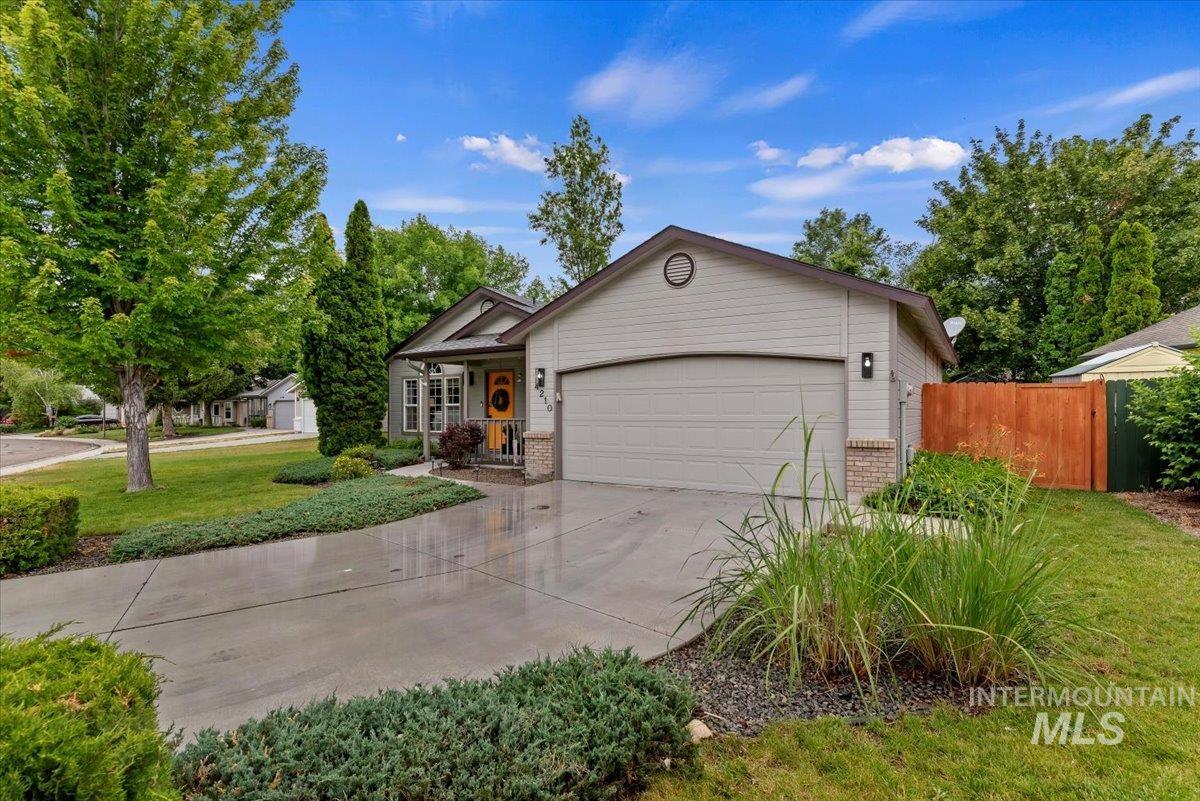 Single-story residence featuring light gray siding, a prominent attached garage, and a covered front porch with a vibrant yellow entry door