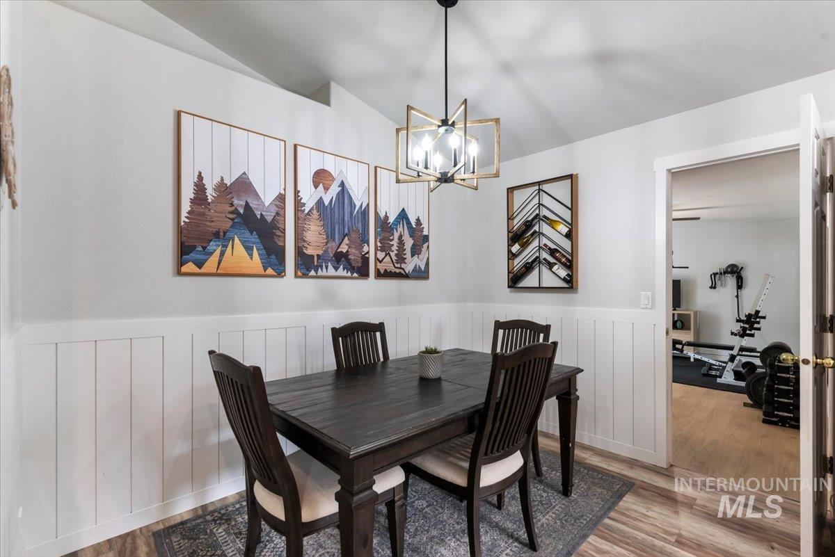 Dining area featuring wood-finish flooring and white wainscoting
