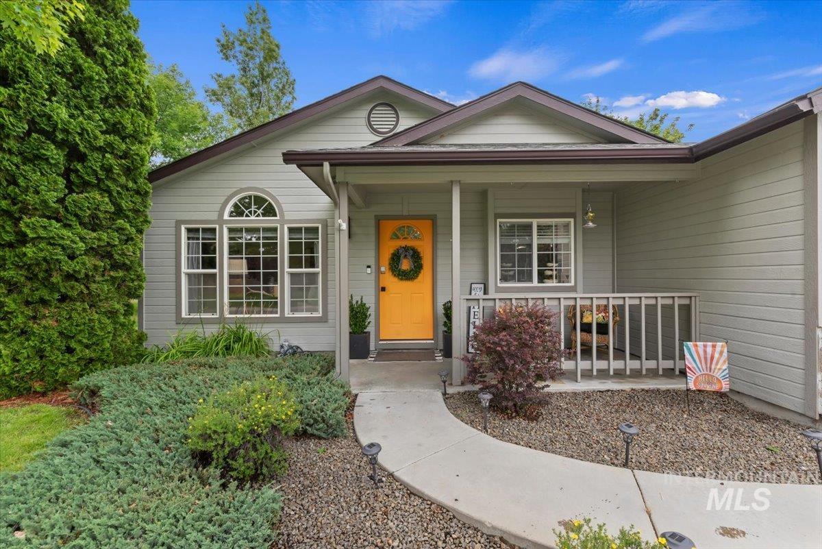 Light gray siding exterior with a bright yellow entry door