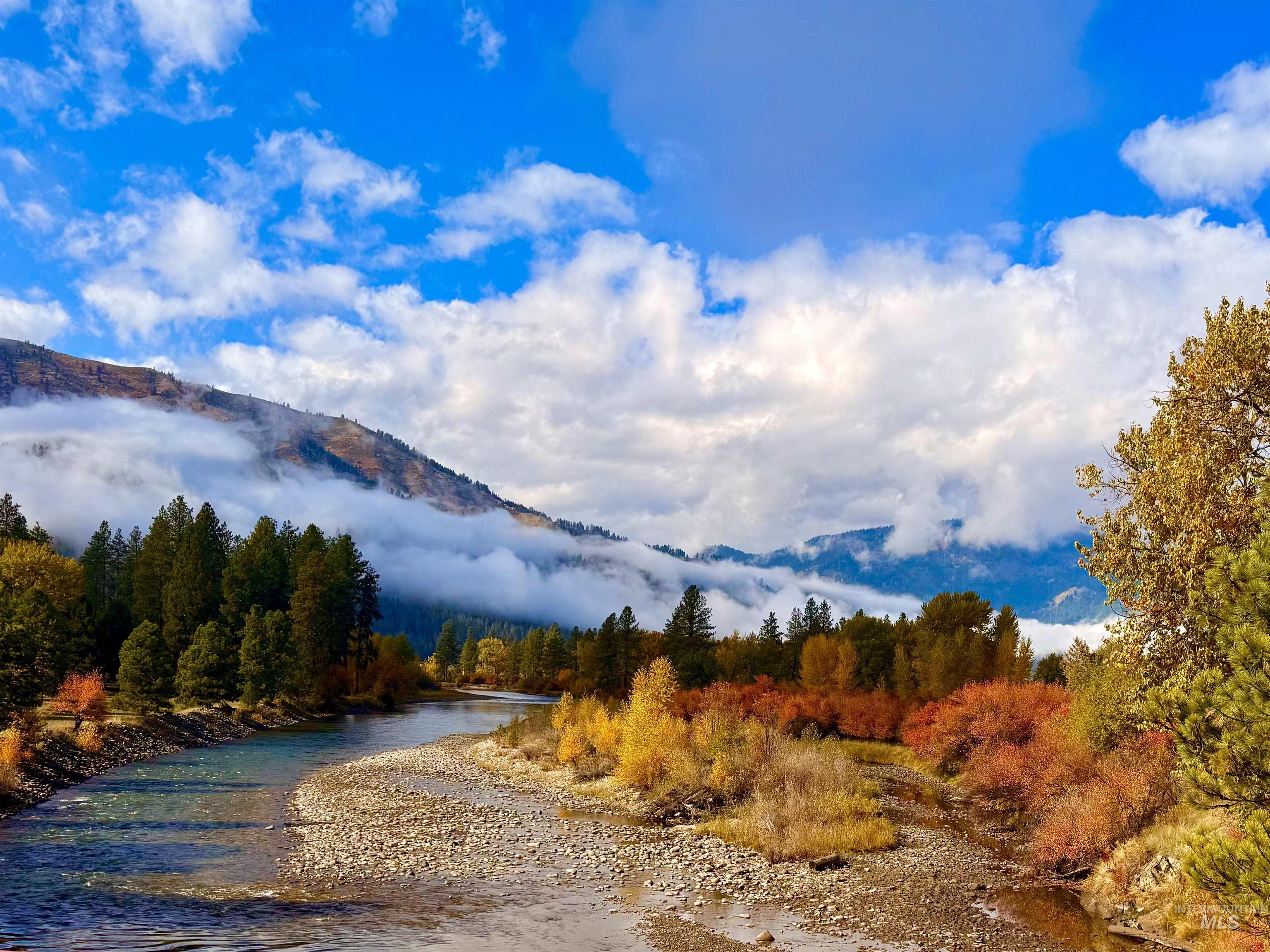 View of mountain backdrop with a nearby body of water and a heavily wooded area